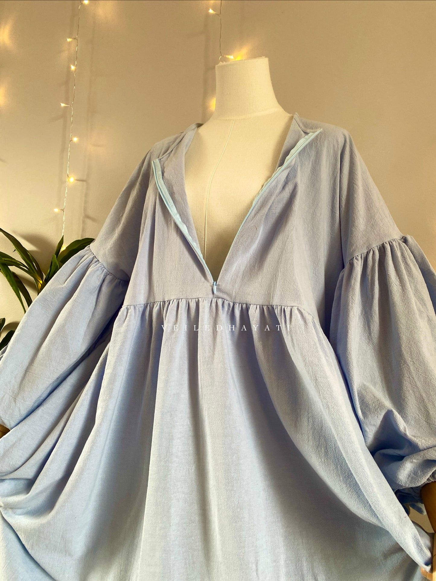 Mannequin wearing a pastel blue organic 100% cotton abaya. Light blue pure cotton abaya. Natural abaya with nursing friendly hidden zipper and deep pockets. Cute modest cotton abaya. All natural.