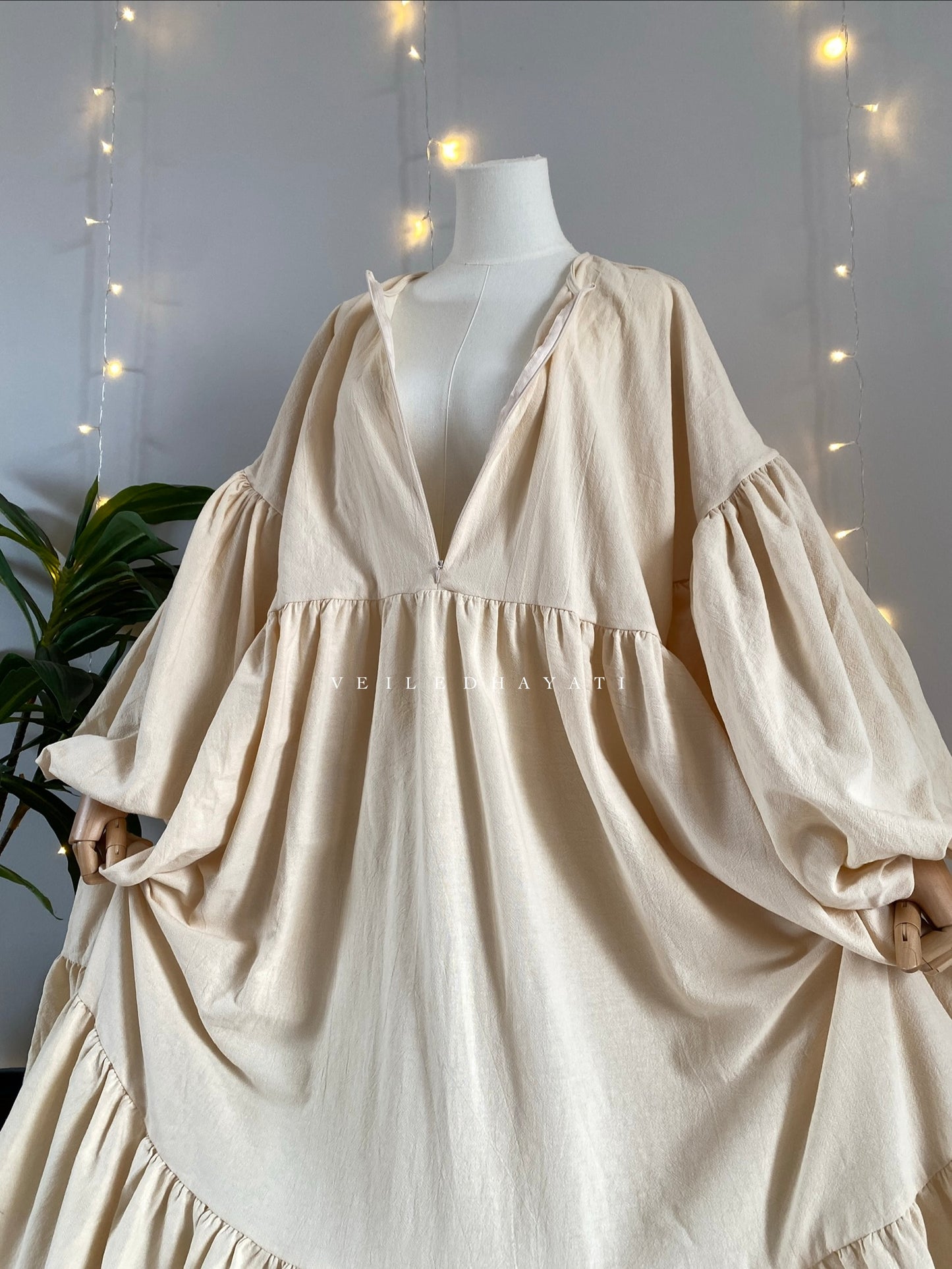 Mannequin wearing a cream / creme colored organic 100% cotton abaya. Light beige pure cotton abaya. Natural abaya with nursing friendly hidden zipper and deep pockets. Cute modest cotton abaya. All natural.
