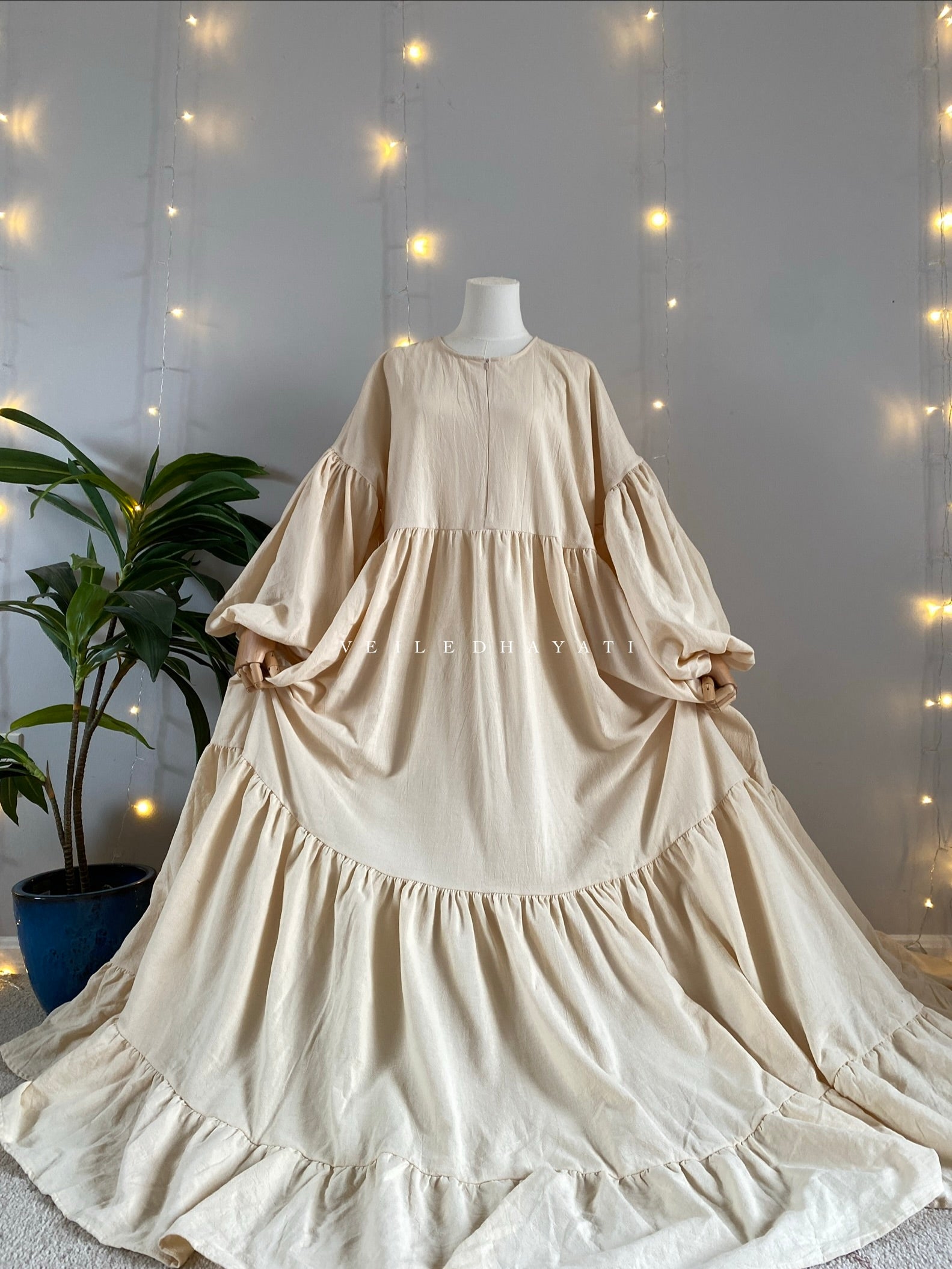 Mannequin wearing a cream / creme colored organic 100% cotton abaya. Light beige pure cotton abaya. Natural abaya with nursing friendly hidden zipper and deep pockets. Cute modest cotton abaya. All natural.