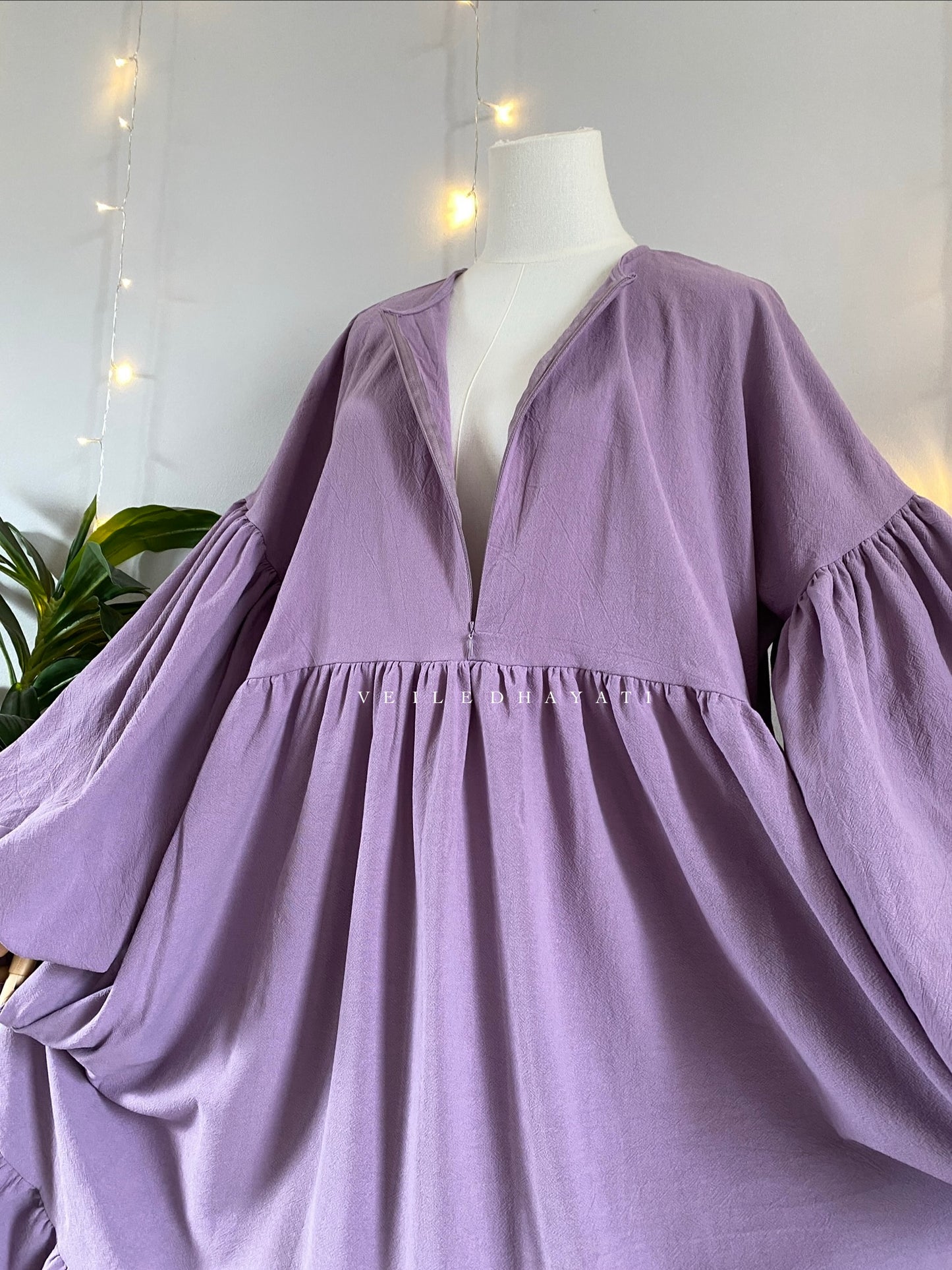 Mannequin wearing a lilac / lavendar colored organic 100% cotton abaya. Purple pure cotton abaya. Natural abaya with nursing friendly hidden zipper and deep pockets. Cute modest cotton abaya. All natural.