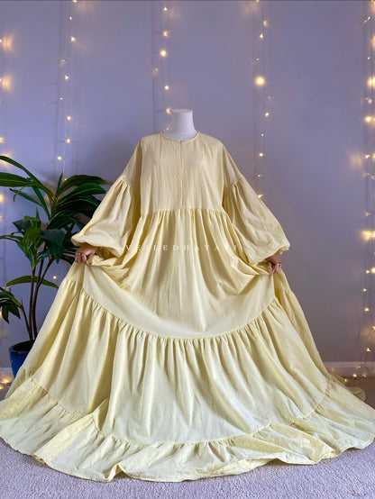 Mannequin wearing a butter yellow organic 100% cotton abaya. Pastel yellow pure cotton abaya. Natural abaya with nursing friendly hidden zipper and deep pockets. Cute modest cotton abaya. All natural.