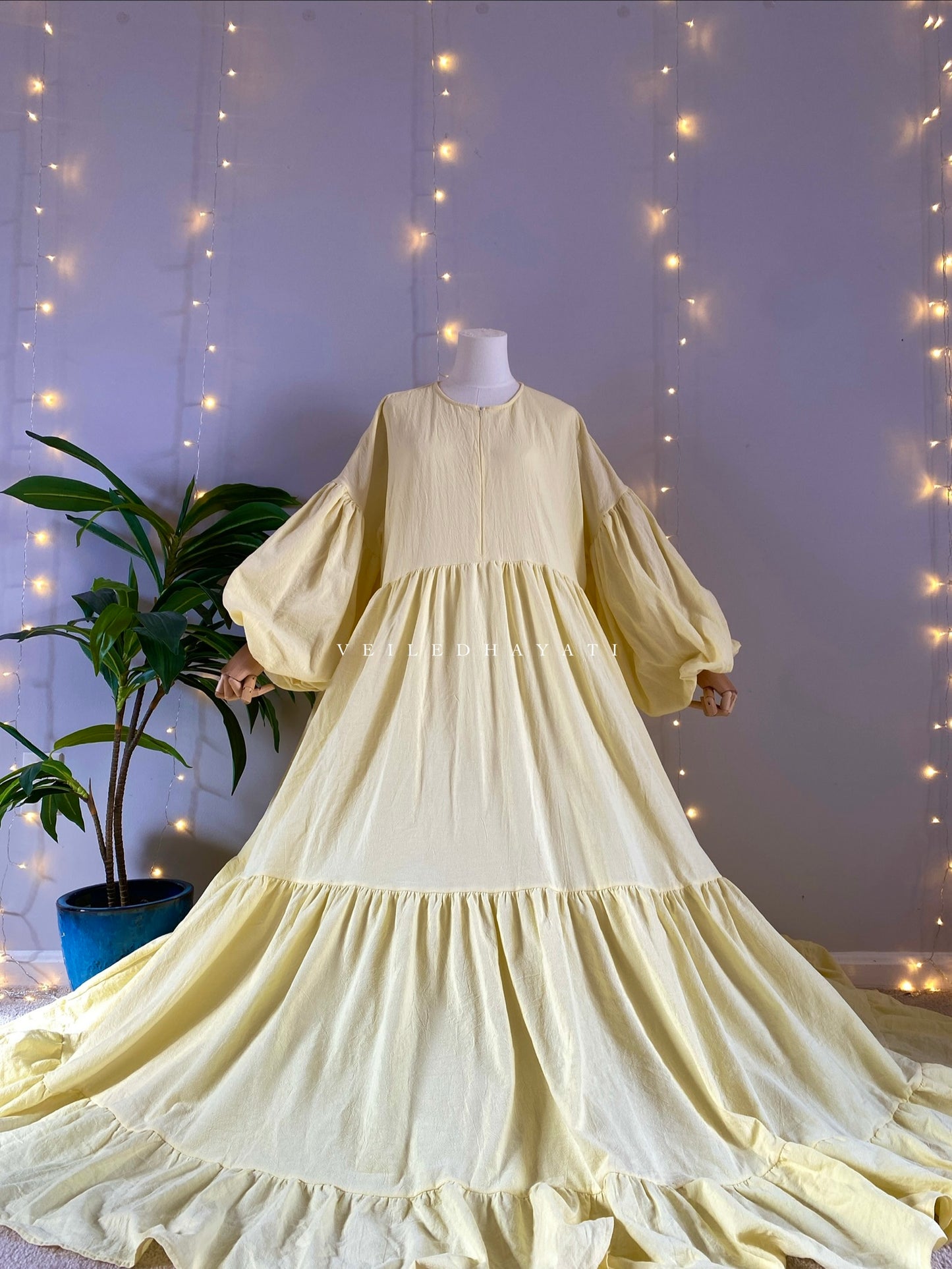 Mannequin wearing a butter yellow organic 100% cotton abaya. Pastel yellow pure cotton abaya. Natural abaya with nursing friendly hidden zipper and deep pockets. Cute modest cotton abaya. All natural.