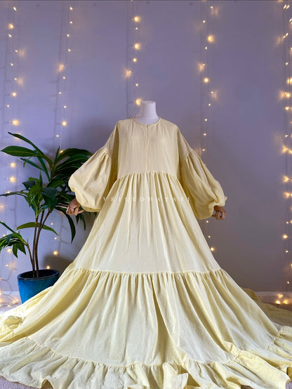 Mannequin wearing a butter yellow organic 100% cotton abaya. Pastel yellow pure cotton abaya. Natural abaya with nursing friendly hidden zipper and deep pockets. Cute modest cotton abaya. All natural.
