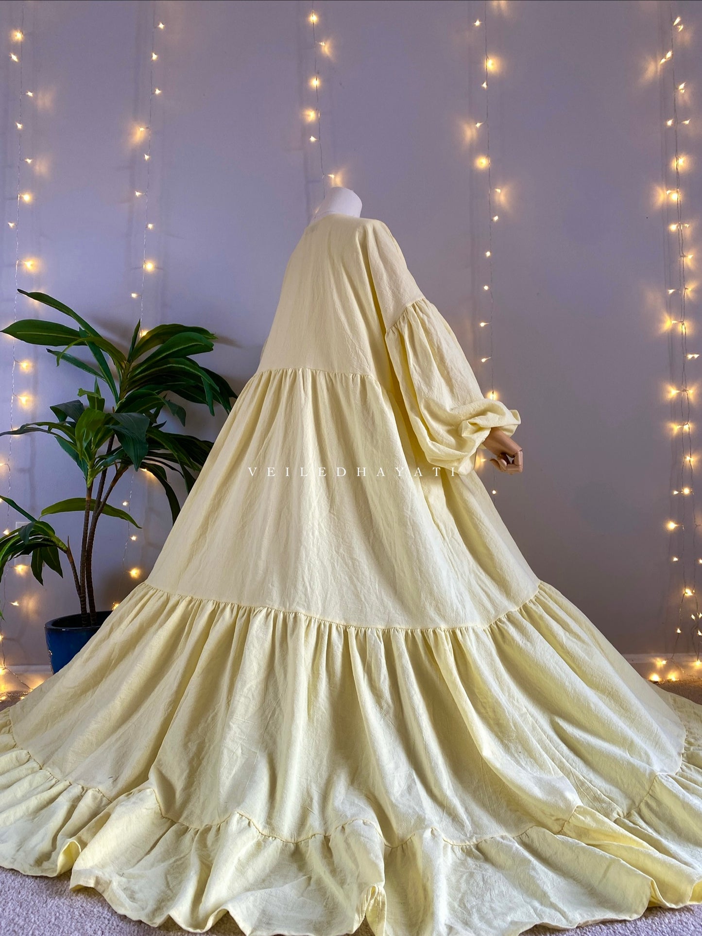 Mannequin wearing a butter yellow organic 100% cotton abaya. Pastel yellow pure cotton abaya. Natural abaya with nursing friendly hidden zipper and deep pockets. Cute modest cotton abaya. All natural.